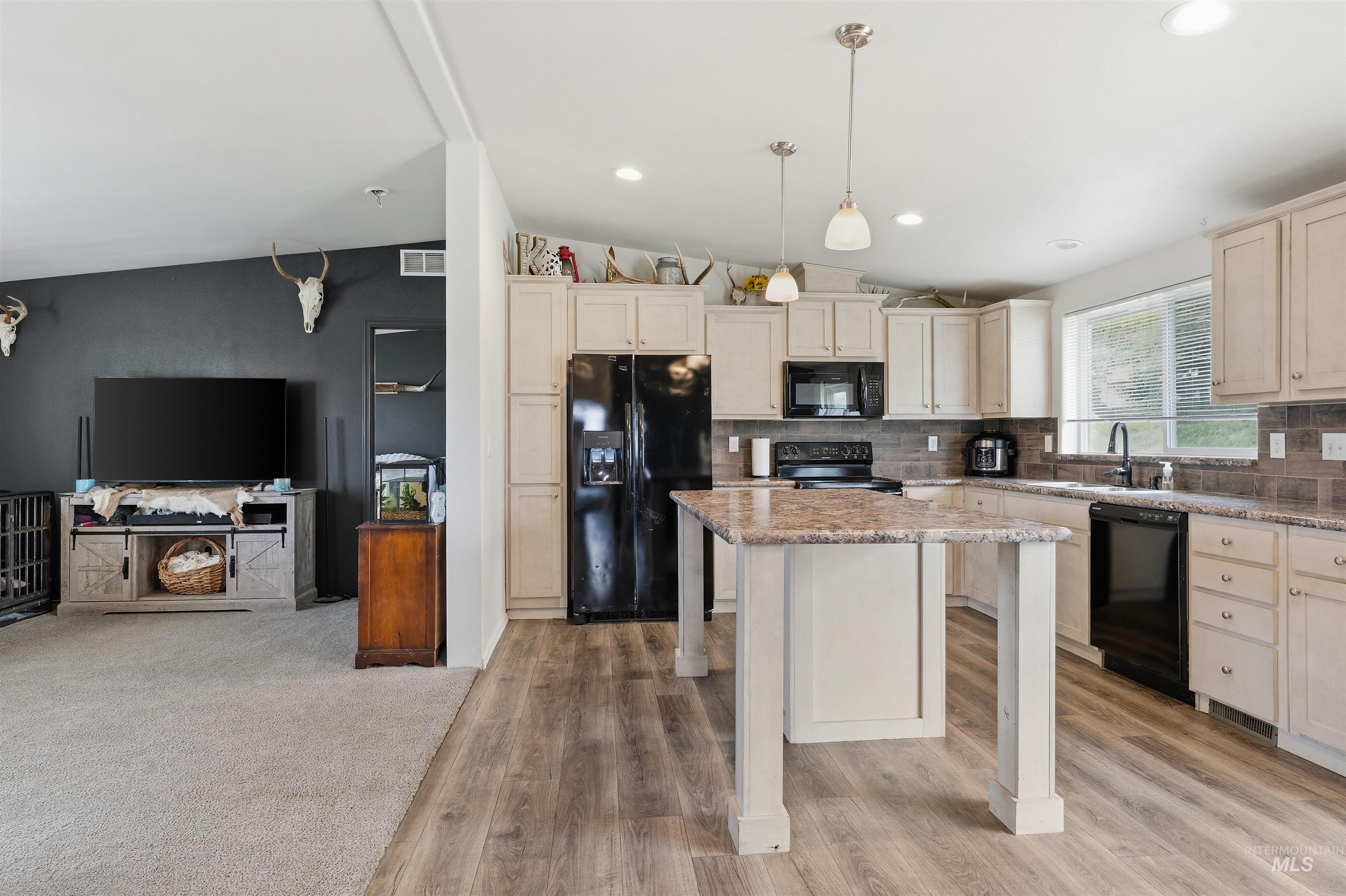 302 3rd Avenue Craigmont, ID 83523 - Photo 28 of 31 Spacious kitchen featuring light-toned cabinetry, dark appliances, a central island with a stone-finish countertop, and wood-finish flooring