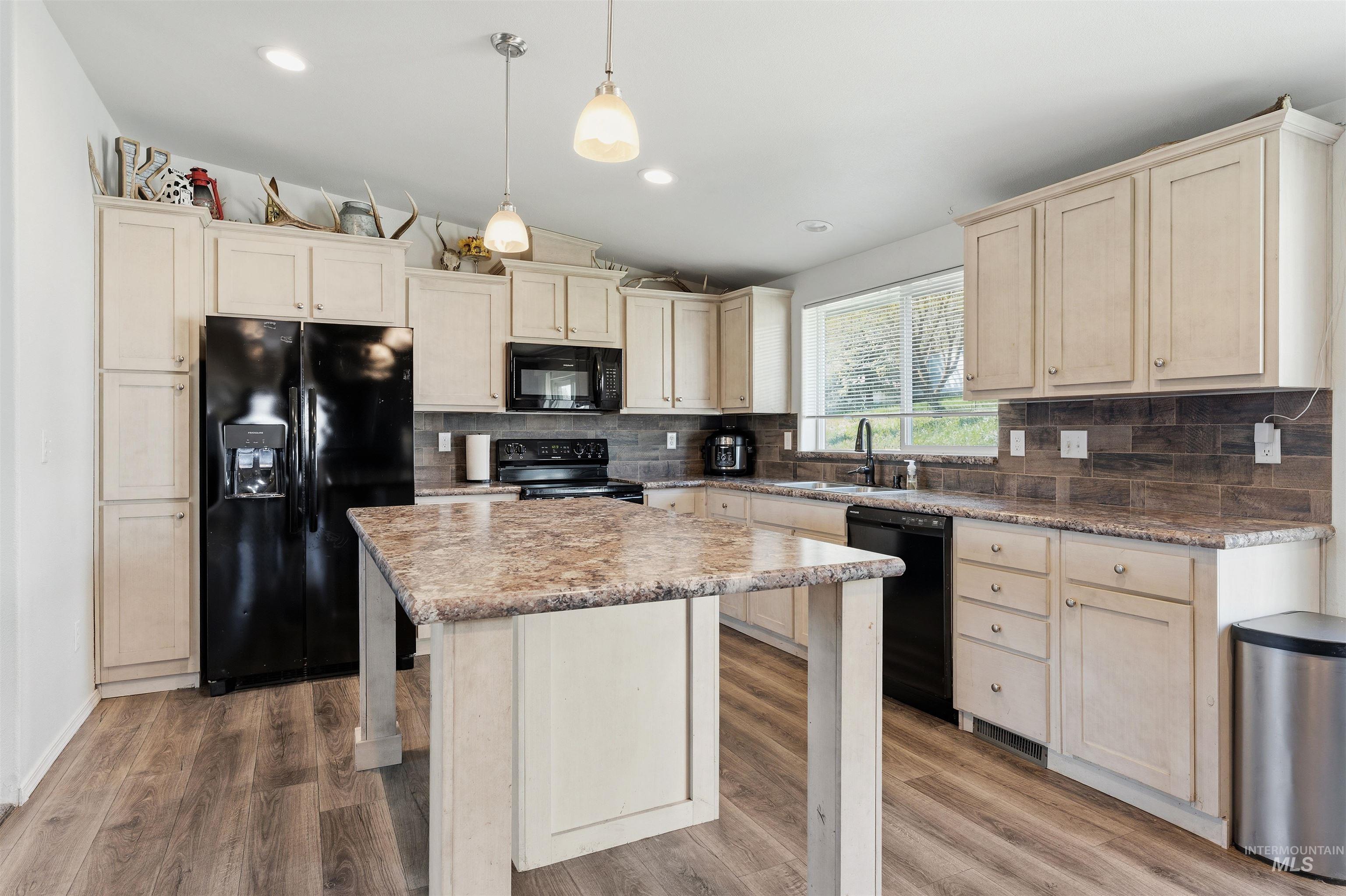 302 3rd Avenue Craigmont, ID 83523 - Photo 3 of 31 Kitchen featuring a central island with stone-finish countertop, light-toned cabinetry, dark-finish appliances, wood-finish flooring, and a window above the sink