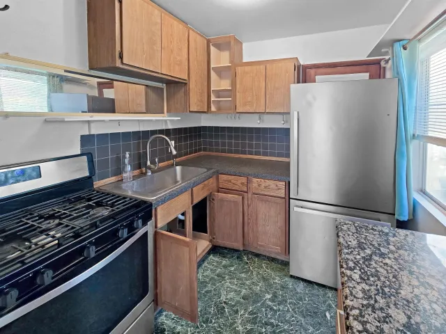 a kitchen with granite countertop a refrigerator and a stove