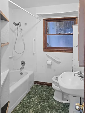 a bathroom with a sink a toilet and shower