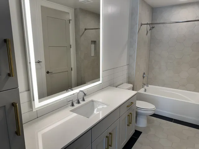a bathroom with a sink a toilet and shower