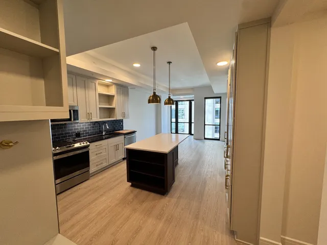 a kitchen with stainless steel appliances granite countertop a sink a stove and a refrigerator