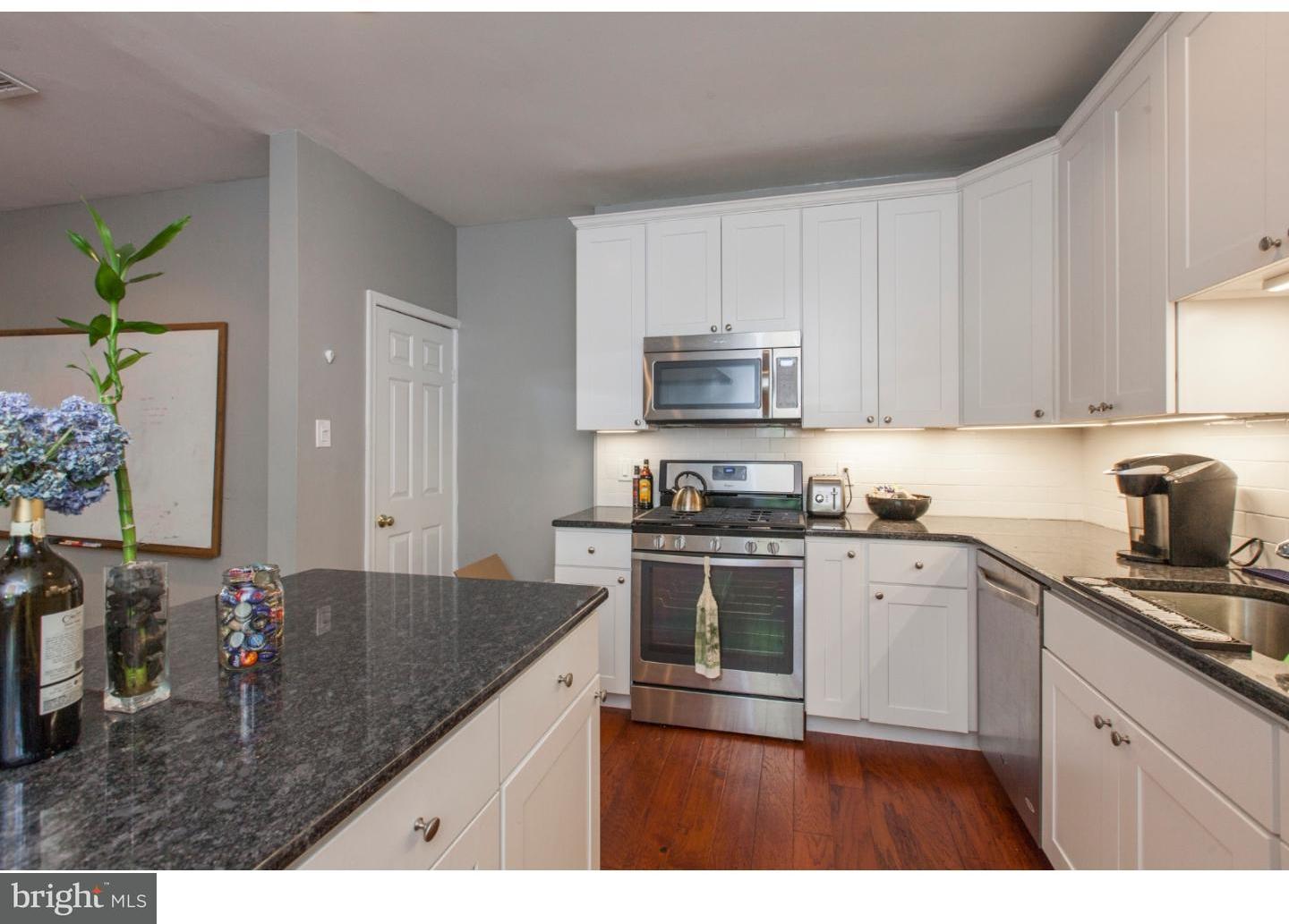 235 Roxborough Avenue Philadelphia, PA 19128 - Photo 8 of 22 a kitchen with kitchen island granite countertop a sink a stove and cabinets