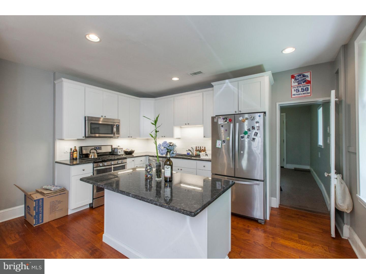 235 Roxborough Avenue Philadelphia, PA 19128 - Photo 9 of 22 a kitchen with stainless steel appliances granite countertop a refrigerator a stove a sink a microwave a dining table and chairs