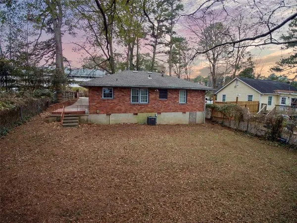 a view of a house with a backyard and a tree