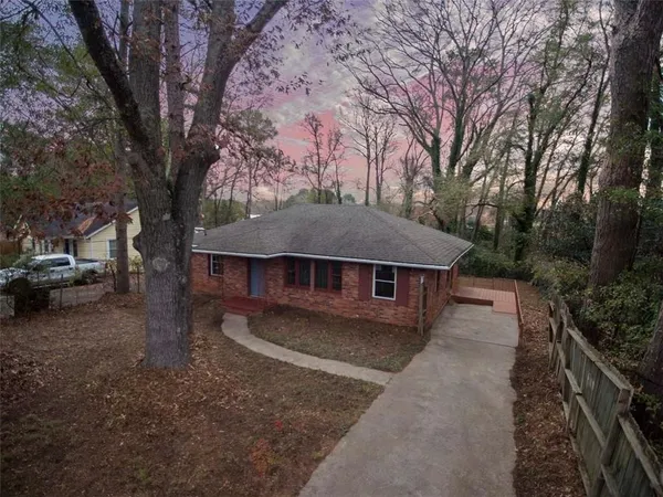 a view of a house with a large tree in front of it