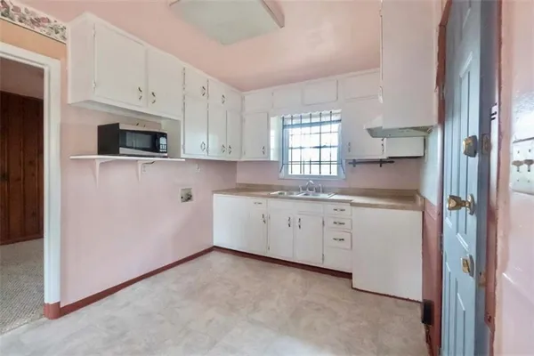 a kitchen with granite countertop white cabinets white stainless steel appliances and a sink