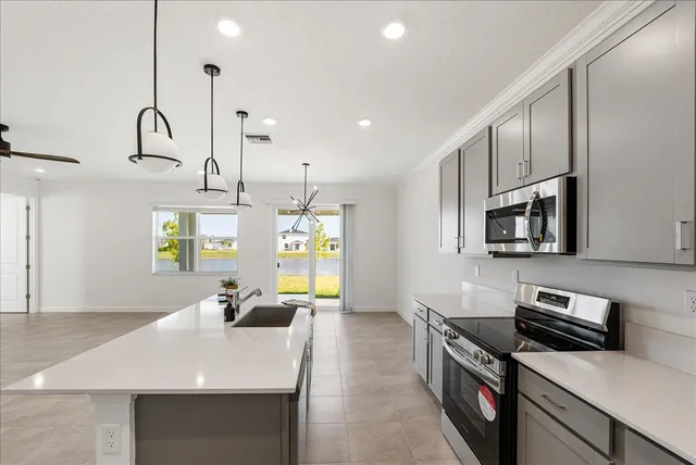 a kitchen with stainless steel appliances granite countertop a sink a stove and a refrigerator
