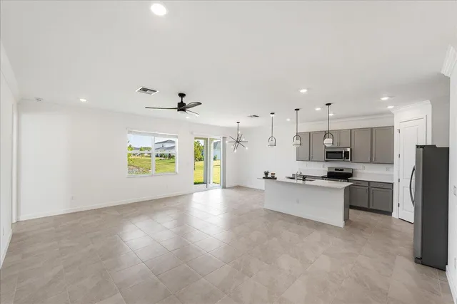 a large kitchen with stainless steel appliances granite countertop a stove a sink a refrigerator and a dining table with wooden floor