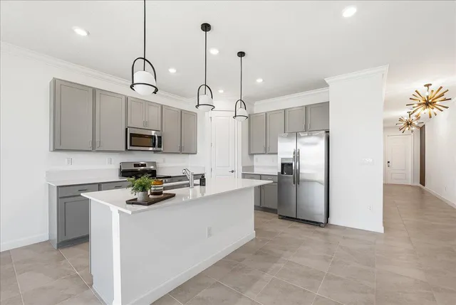 a kitchen with refrigerator a microwave and white cabinets
