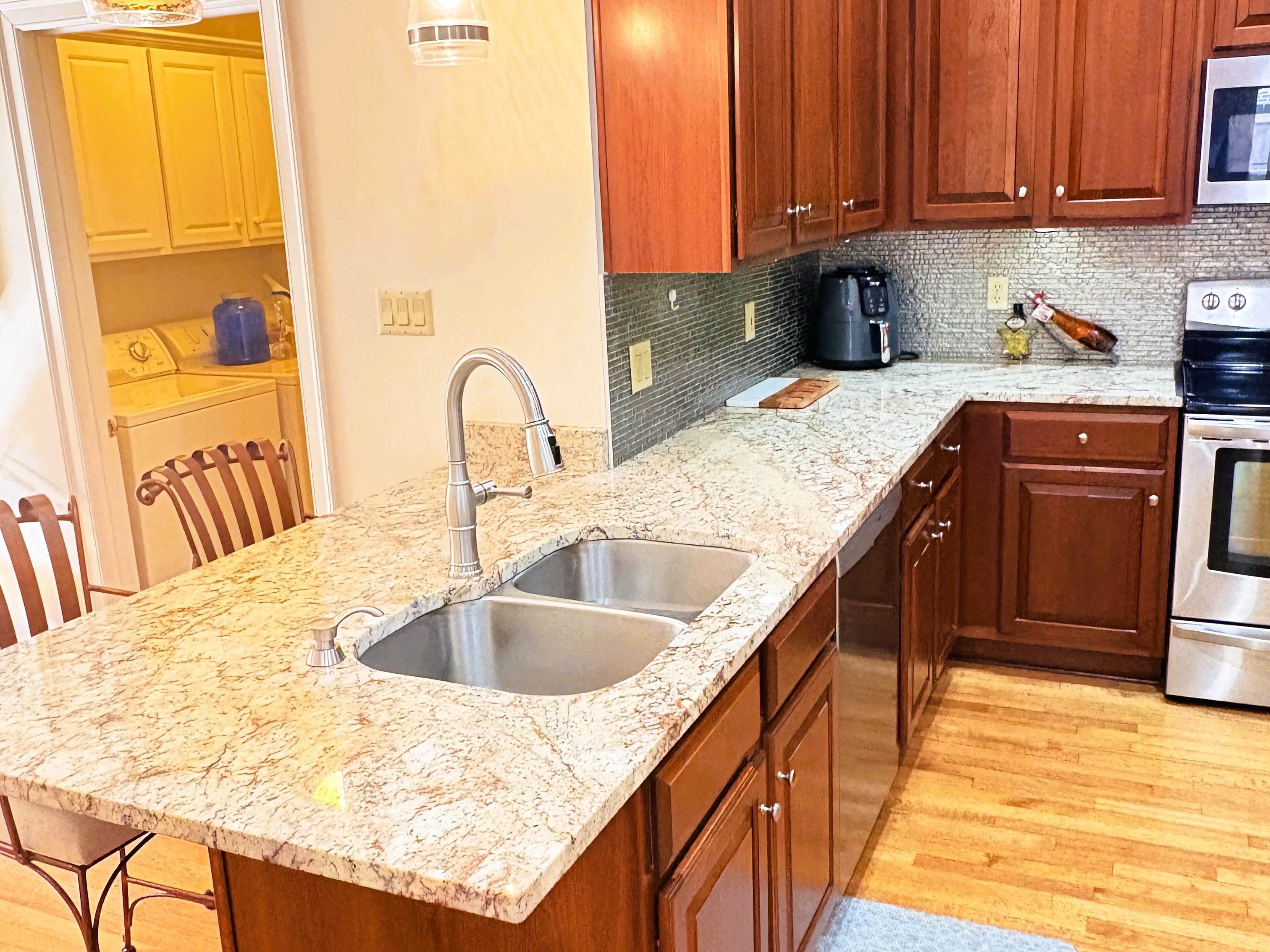 1730 Gosnold Bluff Road Collierville, TN 38017 - Photo 4 of 15 Kitchen featuring light stone counters, stainless steel appliances, light wood-type flooring, tasteful backsplash, and wood finish cabinetry
