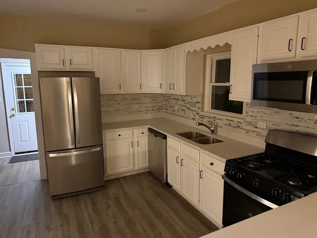 a kitchen with stainless steel appliances a stove microwave and a refrigerator