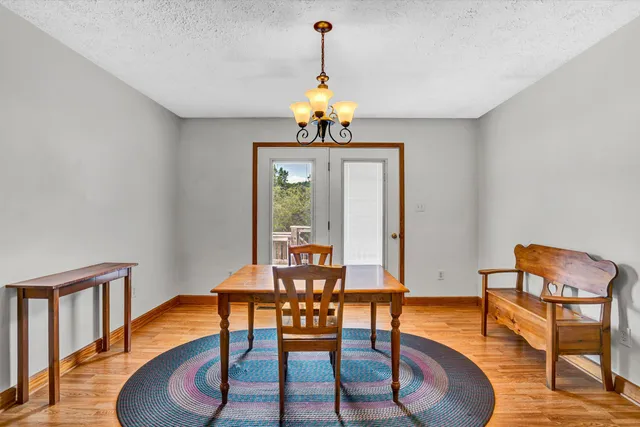 a dining room with furniture a chandelier and wooden floor
