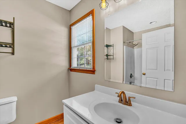 a bathroom with a sink a toilet and shower