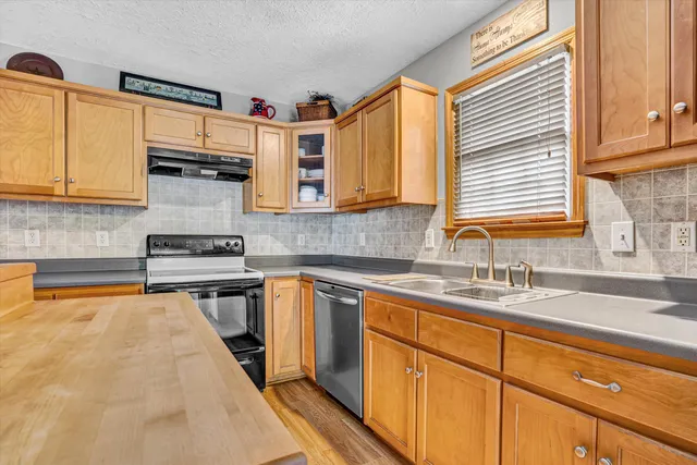 a kitchen with stainless steel appliances a sink stove and cabinets