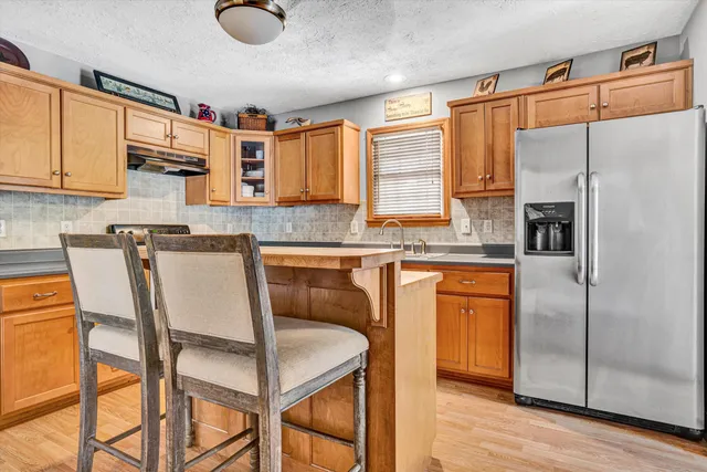 a kitchen with stainless steel appliances granite countertop a stove a sink and a refrigerator