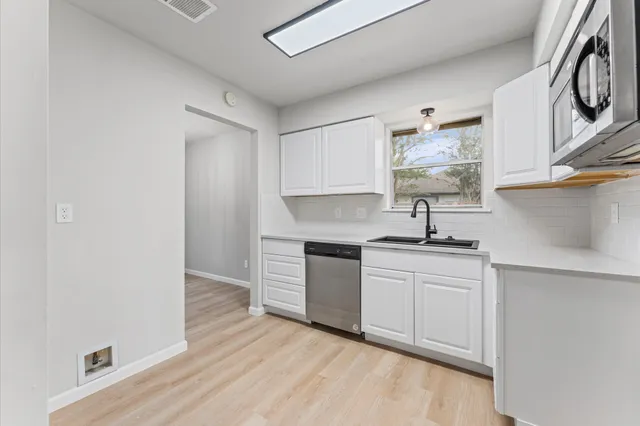 a kitchen with stainless steel appliances granite countertop a sink and stove top oven