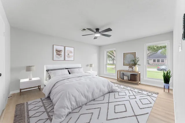 a spacious bedroom with a large bed a fireplace and a chandelier
