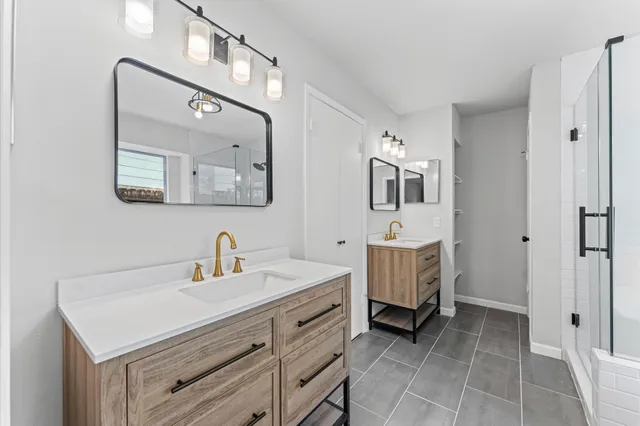 a bathroom with a double vanity sink mirror and bathtub