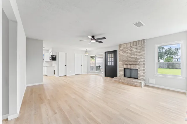 a view of an empty room with a fireplace and a window