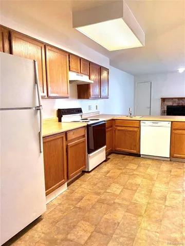 a kitchen with stainless steel appliances granite countertop a sink and a refrigerator