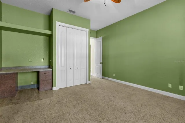a bathroom with a granite countertop sink a mirror and a toilet