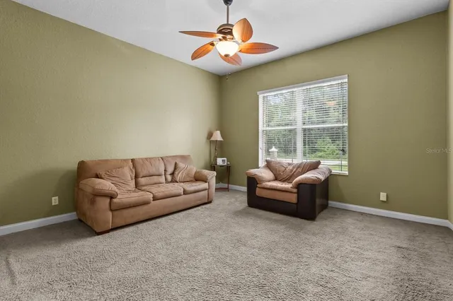 a living room with furniture and a ceiling fan