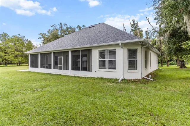 a view of a house with a yard and trees