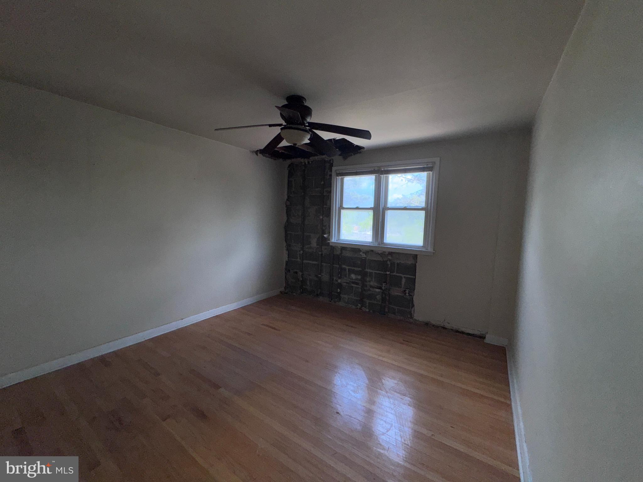 7448 Rhoads Street Philadelphia, PA 19151 - Photo 8 of 17 a view of an empty room with a window and wooden floor