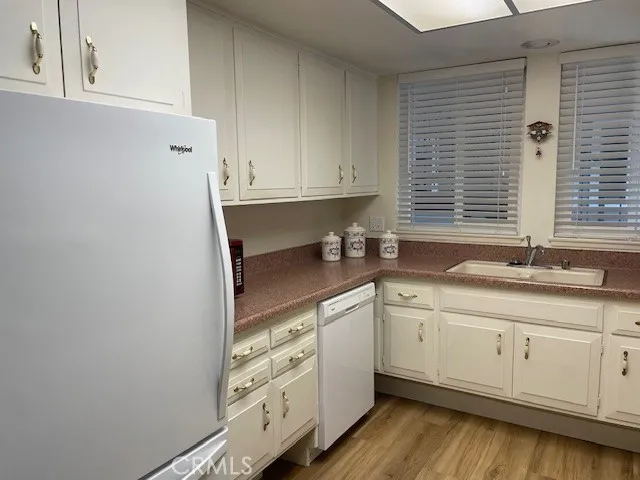 a kitchen with granite countertop white cabinets and white appliances