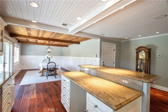 a kitchen with kitchen island granite countertop a sink cabinets stainless steel appliances and a window