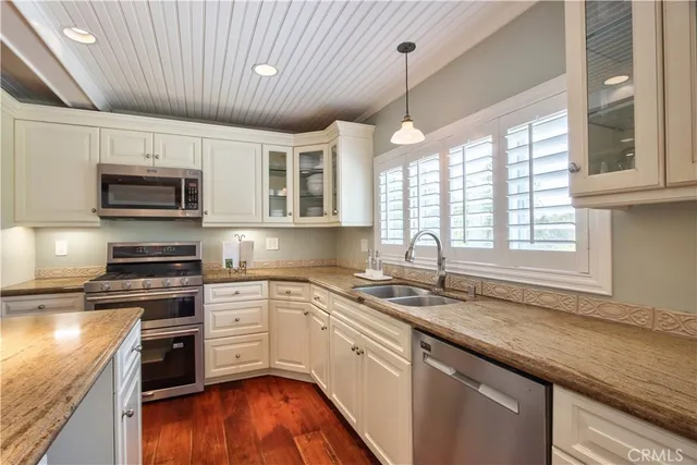 a kitchen with stainless steel appliances granite countertop a refrigerator and a stove top oven