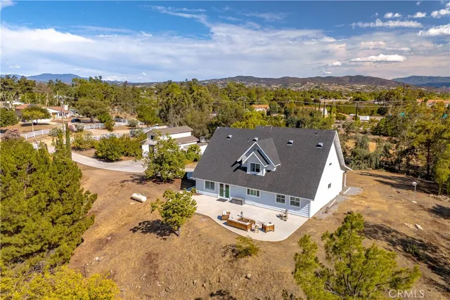 an aerial view of residential houses with outdoor space and mountain view