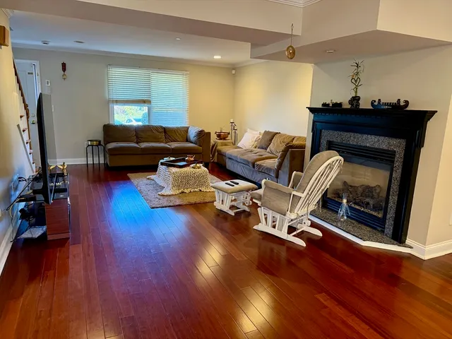 a kitchen with stainless steel appliances granite countertop a stove top oven a refrigerator a dining table and chairs with wooden floor