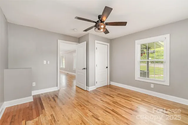 a view of a livingroom with a ceiling fan and wooden floor