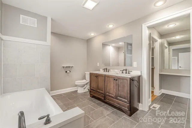 a spacious bathroom with a tub sink and mirror
