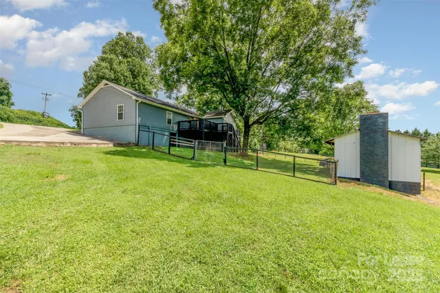 a view of a house with a backyard and a tree