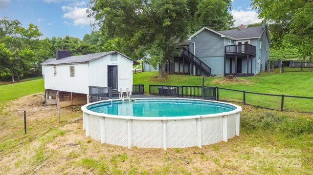 a view of a house with a yard and large tree