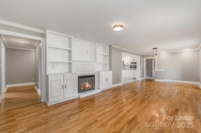 a view of empty room with wooden floor and fireplace
