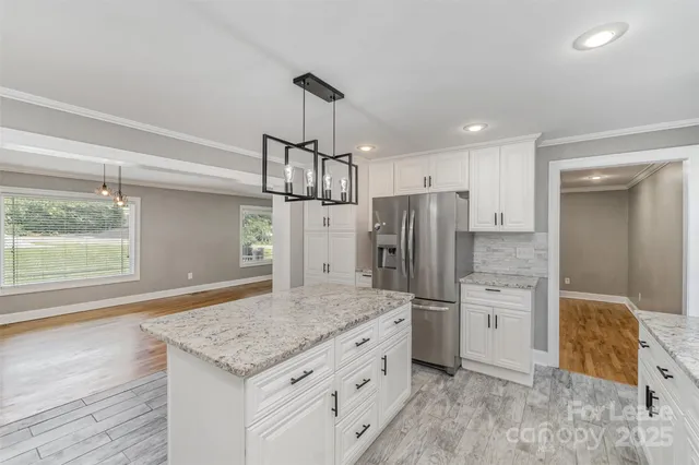 a kitchen with stainless steel appliances kitchen island granite countertop a refrigerator and microwave