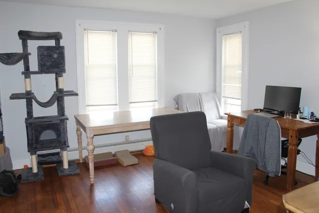 a living room with furniture and a flat screen tv with wooden floor