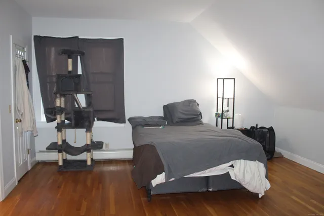 a bedroom with a bed and wooden floor