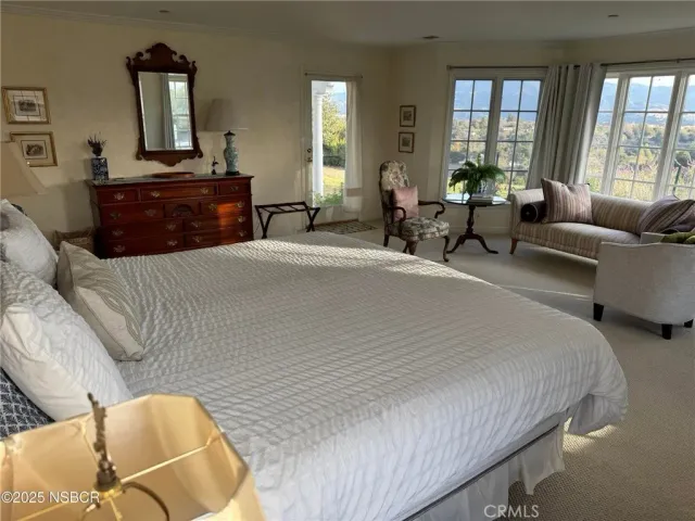 a bedroom with a bed and glass windows