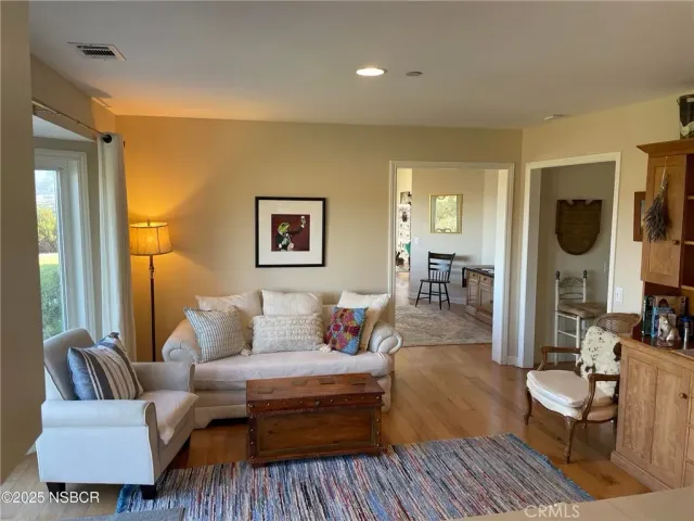 a living room with furniture and a wooden floor