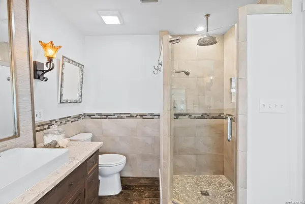 a bedroom with a bed and a mirror on dresser