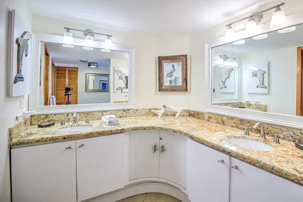 a bathroom with a granite countertop sink and a mirror