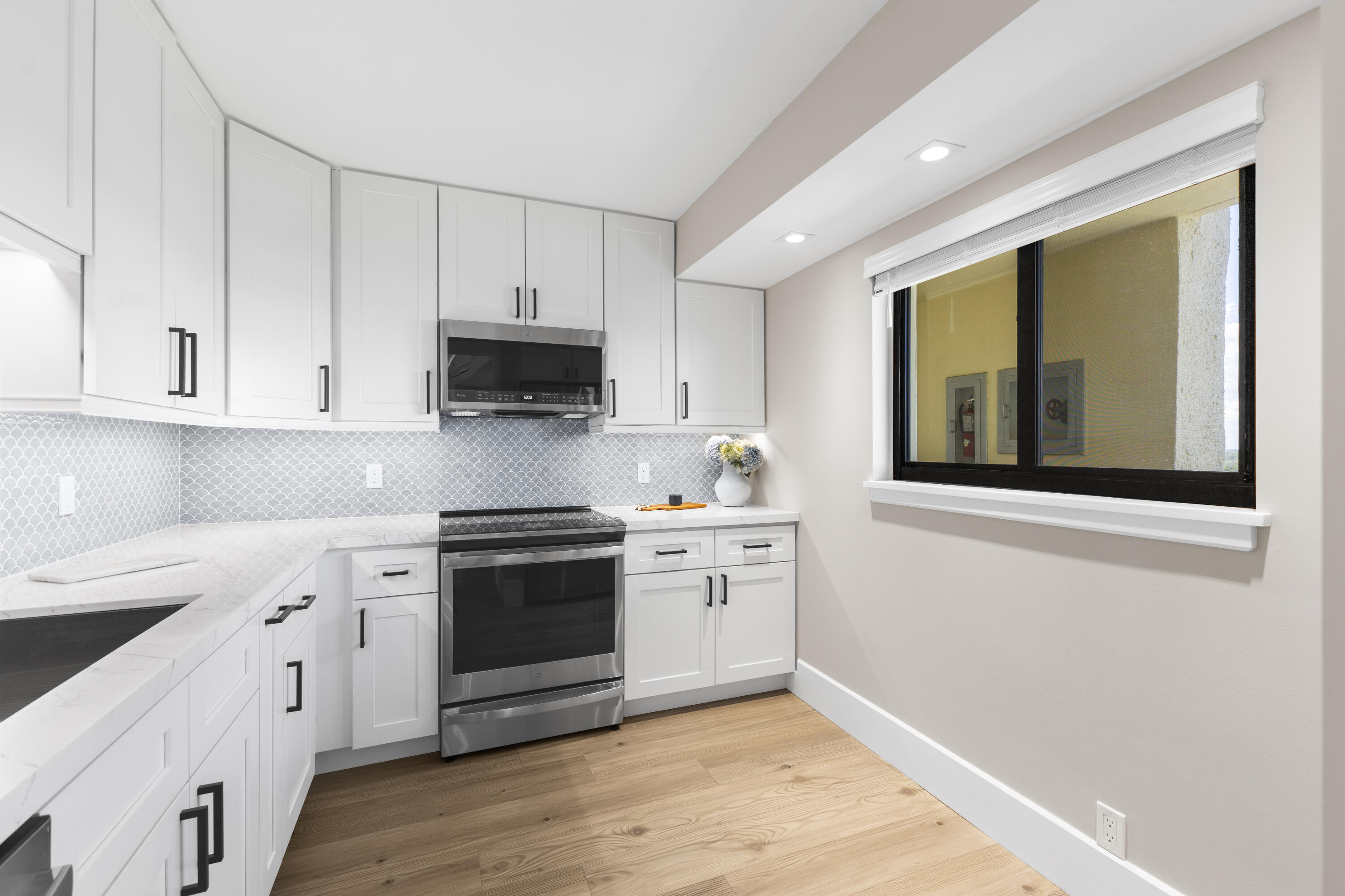 400 Ocean Trail Way, Unit 1008 Jupiter, FL 33477 - Photo 8 of 25 a kitchen with stainless steel appliances granite countertop a stove and a white cabinets