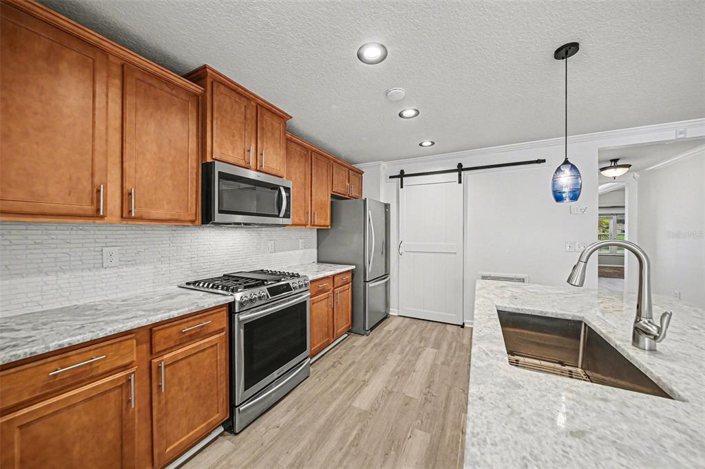 111 Lakeside Court Bunnell, FL 32110 - Photo 8 of 27 a kitchen with granite countertop a stove a sink and a microwave