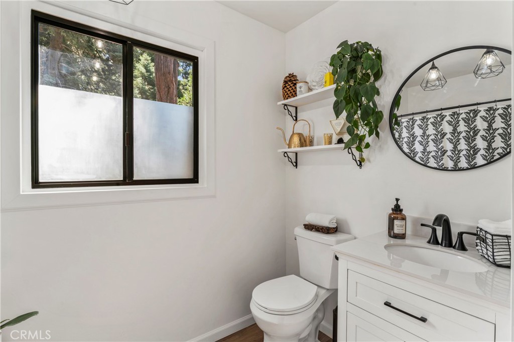 899 Blue Ridge Drive Lake Arrowhead, CA 92385 - Photo 18 of 49 a bathroom with a toilet sink and mirror