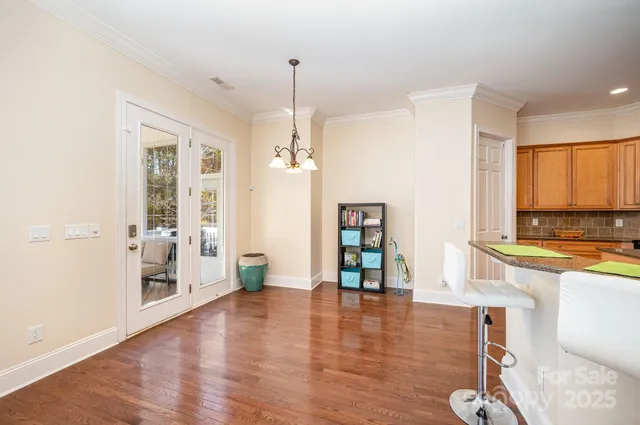 a dining room with wooden floor a chandelier
